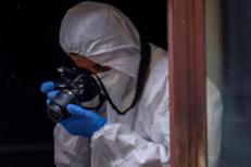 Poliziotto della scientifica al lavoro - Fotogramma