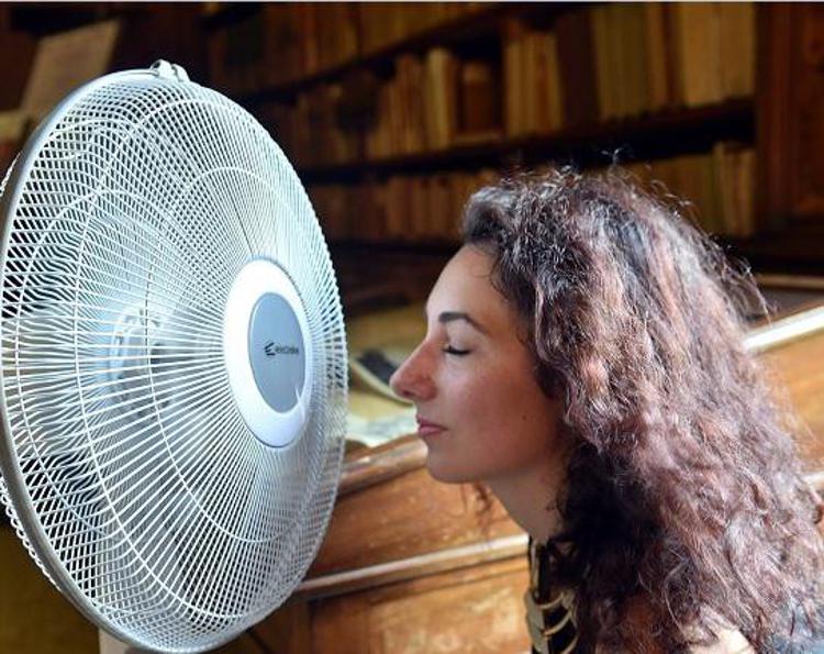 Donna cerca refrigerio davanti a ventilatore - Fotogramma