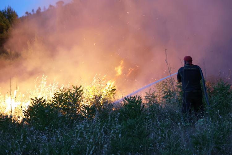 Vigile del fuoco  alle prese con un incendio - Fotogramma