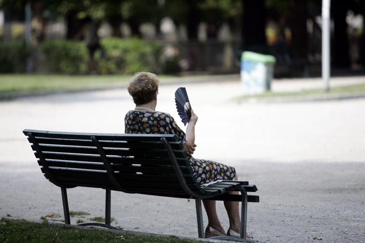 Signora che prende il fresco al parco (Fotogramma)
