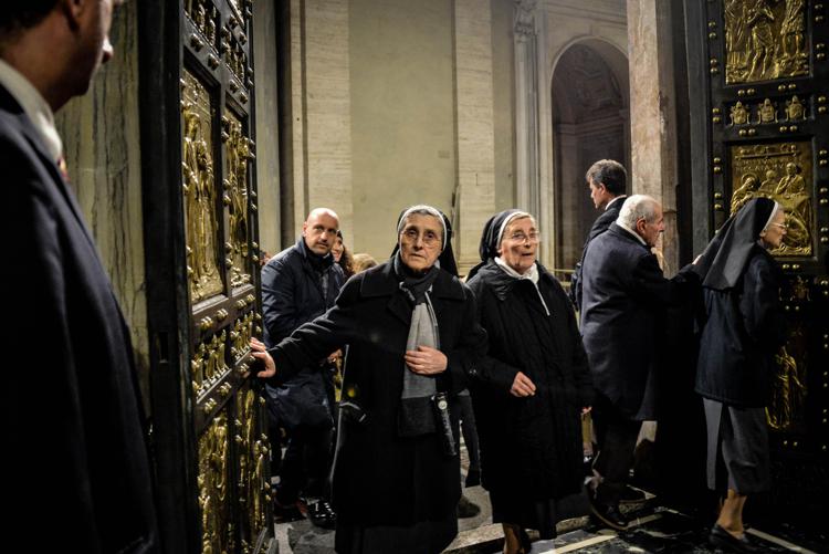 Fedeli varcano la Porta Santa della basilica di San Pietro a Roma (Fotogramma)