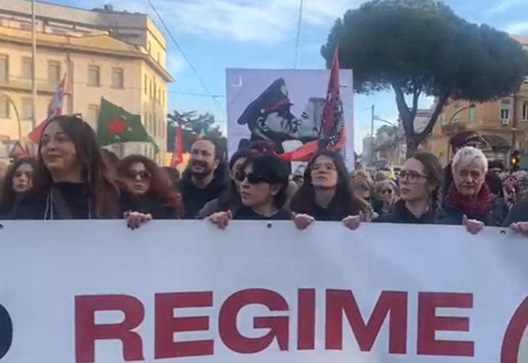 La testa del corteo con il manifesto di Mussolini che bacia Meloni - Adnkronos