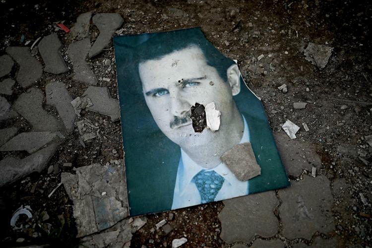 L'immagine di Assad calpestata dai ribelli (Afp)