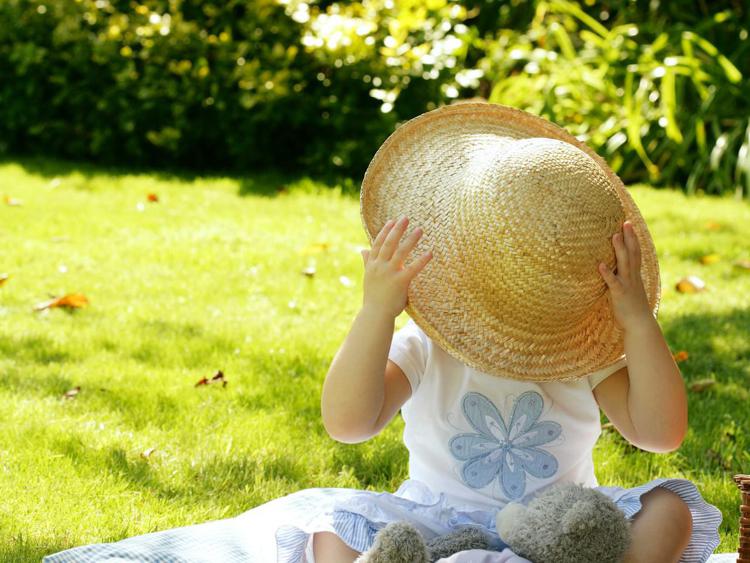 Una bambina con il cappello per ripararsi dal sole (Foto )